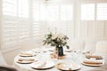 MOdern wedding decor - guest tables with white tableclothes, golden plates, white roses and eucalyptus leaves floral arrangements Royalty Free Stock Photo