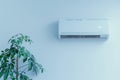 Modern white air conditioner purifier mockup in bright living room setting with home plants
