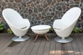 Modern white armchairs and table, modern garden furniture. Cozy space for relax in the garden. Royalty Free Stock Photo