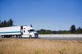 Modern white big rig semi truck with reefer trailer running on h Royalty Free Stock Photo