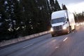 Modern white big rig semi truck with trailer moving by wide high Royalty Free Stock Photo