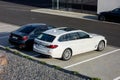 The modern white BMW 530d touring vehicle and other BMWs at the dealership ready for test drive