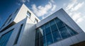 Modern white building with large glass windows against a blue sky with clouds architecture Royalty Free Stock Photo