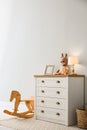 Modern white chest of drawers near light wall in child room. Interior design Royalty Free Stock Photo