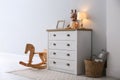 Modern white chest of drawers near wall in child room. Interior design Royalty Free Stock Photo