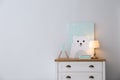 Modern white chest of drawers near light wall in child room, space for text. Interior design Royalty Free Stock Photo