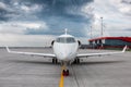 Modern white corporate airplane on the airport apron on a cloudy day