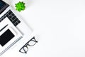 Modern white desk with laptop computer, notebook and smartphone with black screen on laptop. The top view has a copy area Royalty Free Stock Photo