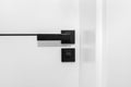 Modern white door with matte black handle and magnetic locks, bathroom door lock. Royalty Free Stock Photo