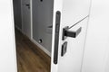 Modern white door with matte black handle and magnetic locks, lock with insert key. Royalty Free Stock Photo