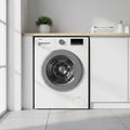 Modern White Front Loading Washing Machine in a Laundry Room Setting with Towels and Plant Royalty Free Stock Photo