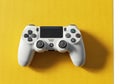 Modern white game controller resting on vibrant yellow surface overhead view Royalty Free Stock Photo