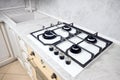 Modern white gas stove on counter top closeup. Hob gas stove made of tempered white glass using natural gas or propane Royalty Free Stock Photo