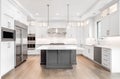 Modern white and grey kitchen with stainless steel appliances.