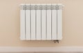 Modern white heating radiator on the wall in apartment room, front view