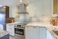 Modern white kitchen design with silver backsplash