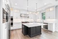 A modern white kitchen with a large grey island.