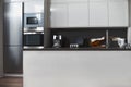 Modern white kitchen, minimalist interior with sunlight in daytime. Full set of kitchen equipment