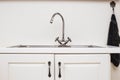 Modern white kitchen with wood accents and iron sink close-up retro design Royalty Free Stock Photo