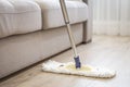 Modern white mop being used for cleaning a wooden floor Royalty Free Stock Photo