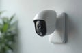 Modern white motion sensor camera mounted on gray wall. Device monitors space for security and safety. Indoor surveillance Royalty Free Stock Photo