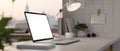 Modern white office desk with open laptop mockup, table lamp, coffee cup and accessories Royalty Free Stock Photo