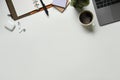 Modern white office desk table with laptop computer, cup of coffee and notebook. Top view with copy space, flat lay. Royalty Free Stock Photo