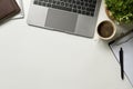 Modern white office desk table with laptop computer, cup of coffee and notebook. Top view with copy space, flat lay. Royalty Free Stock Photo