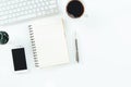 Modern white office desk table with laptop computer, smartphone with black screen over a notebook and cup of coffee. Top view with Royalty Free Stock Photo