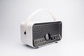 Modern white portable Bluetooth speaker with textured front, positioned off-center on a light gray surface Soft indoor lighting. m Royalty Free Stock Photo