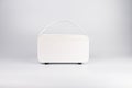 A modern, white, portable generator mini guitar amplifier speaker with a handle and visible output sockets on a reflective surface Royalty Free Stock Photo