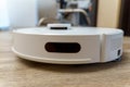 Modern white robotic vacuum cleaner. Self Drive Cleaning Robot. Floor Cleaning System. Selective focus