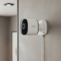 Modern White Security Camera Mounted on a Textured Wall Royalty Free Stock Photo