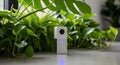 Modern White Smart Home Security Camera Surrounded by Lush Green Plants Royalty Free Stock Photo