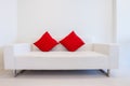 Modern white sofa with red pillows Royalty Free Stock Photo