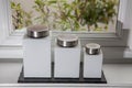 Modern white storage jars on kitchen window sill.