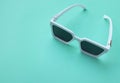 Modern white sunglasses fashion on pastel green background.