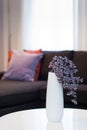 Modern white vase with violet flower in living room Royalty Free Stock Photo