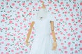 Modern white wedding dress on a mannequin with blured flower background Royalty Free Stock Photo