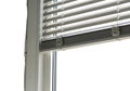 Modern white window with horizontal blinds partially open, letting in natural light Royalty Free Stock Photo