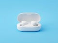 Modern white wireless earbuds with charging case on a vibrant blue background Royalty Free Stock Photo