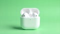 White wireless earbuds in charging case on green Royalty Free Stock Photo