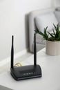 Modern Wi-Fi router on white table in room Royalty Free Stock Photo