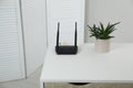 Modern Wi-Fi router on white table in room Royalty Free Stock Photo