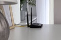 Modern Wi-Fi router on white table in room Royalty Free Stock Photo