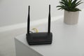 Modern Wi-Fi router on white table in room. Space for text Royalty Free Stock Photo