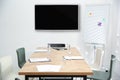 Modern wide screen TV on white wall in conference room