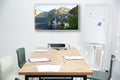 Modern wide screen TV on white wall in conference room