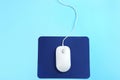 Modern wired mouse and pad on blue background, top view Royalty Free Stock Photo