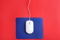 Modern wired optical mouse and pad on red background Royalty Free Stock Photo